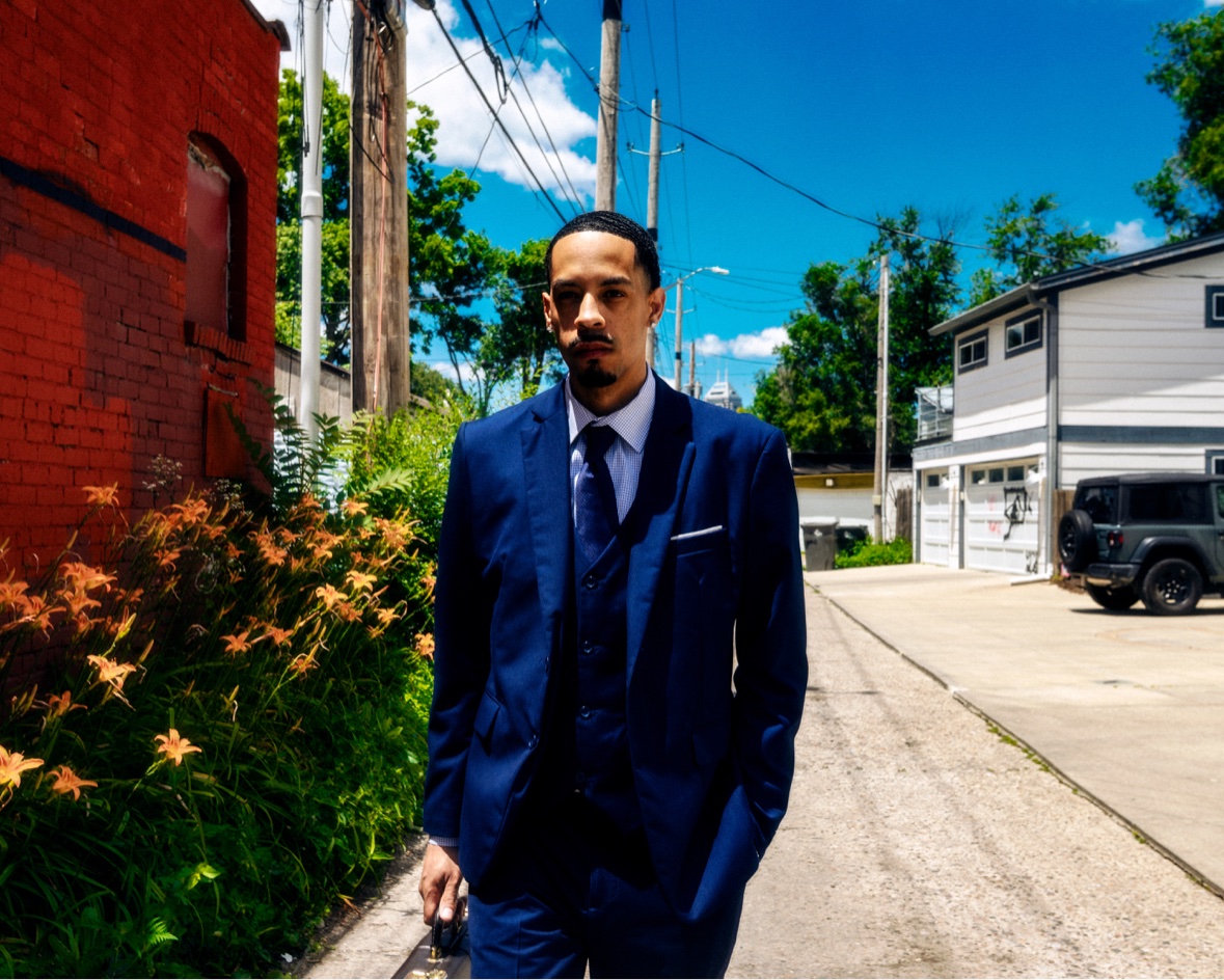 Navy suit walking toward camera in an alley