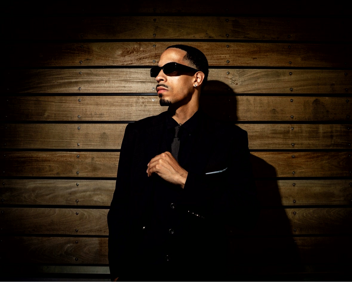 Black suit against wood-paneled wall